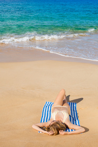 美丽的女人放松热带海滩上