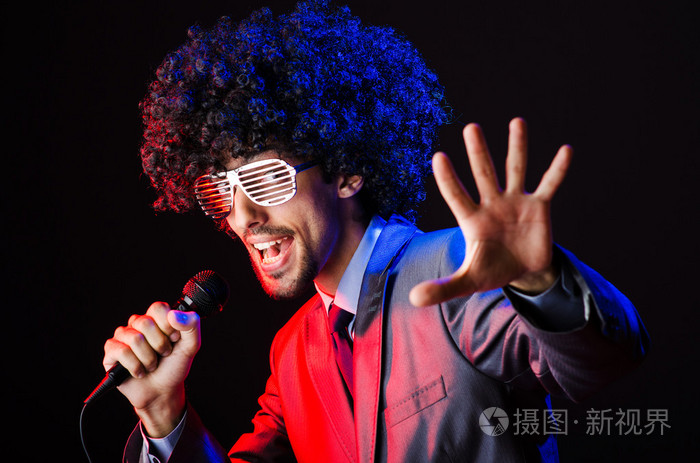 在非洲裔的青年歌手假发唱歌在迪斯科