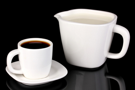 一杯浓咖啡和甜奶油孤立在黑色