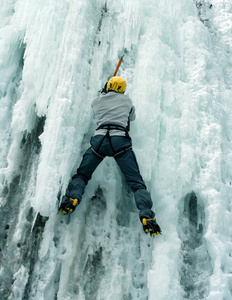 男子攀爬冰的瀑布图片