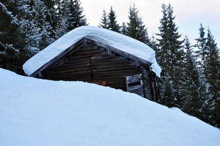 新鲜雪覆盖的山间木屋