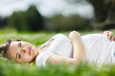 孕妇躺在公园的绿草上