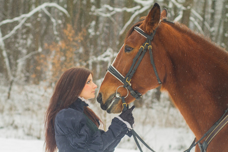 美丽的女人和马在冬季