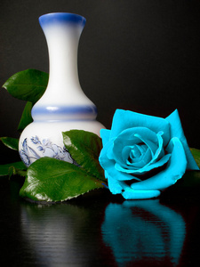 旁边一个白色的装饰花瓶大玫瑰