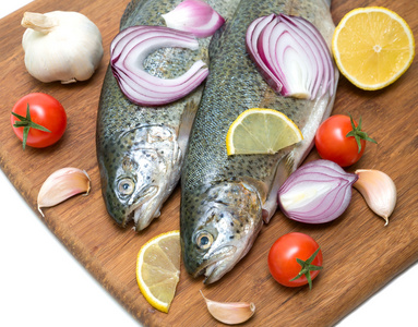 鳟鱼 蔬菜和柠檬在菜板上