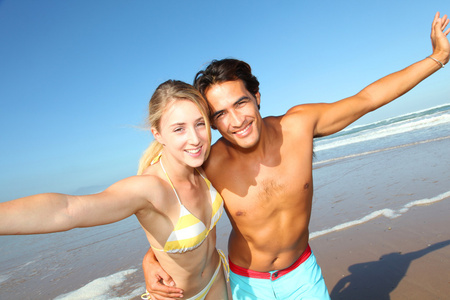 年轻夫妇在海滩很开心