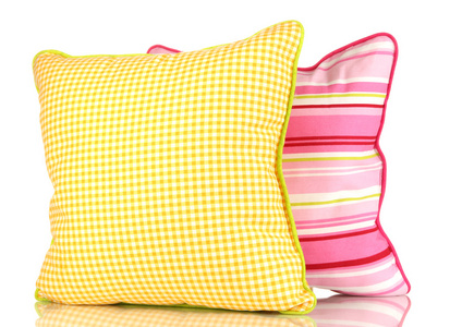 黄色和粉红色明亮枕头上白色隔离