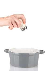 手工添加盐使用隔离在白色的盐瓶