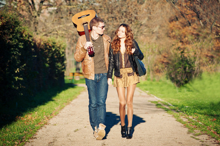 年轻夫妇和户外在一个公园的吉他走的浪漫心情