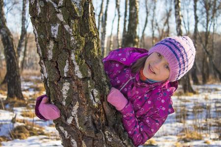 树在冬季森林附近的小女孩