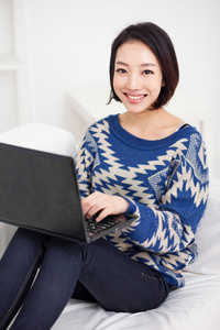 使用便携式计算机的年轻亚裔女子