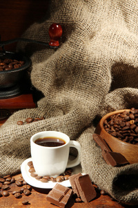咖啡研磨机和杯咖啡棕色木制背景上