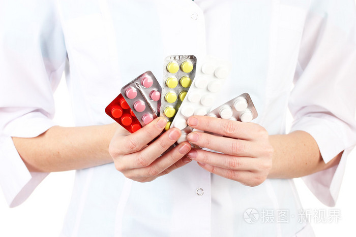 拿药片,白色上孤立的女医生手的特写