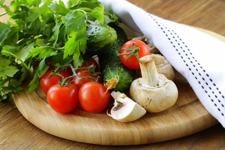 西红柿 黄瓜 蘑菇和欧芹在菜板上