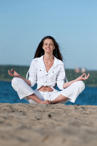 女人练瑜伽在海滩上