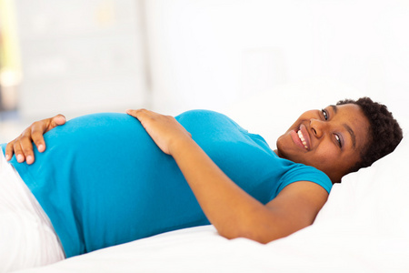 非洲裔美国孕妇躺在床上