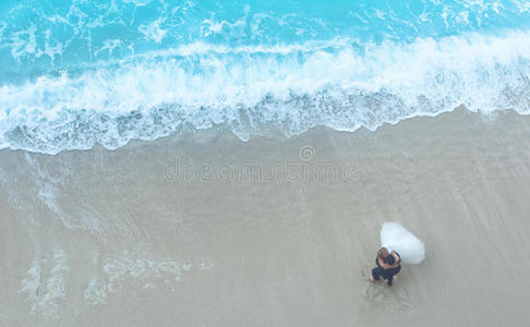 白色的沙滩和蓝色的海水与美丽的新郎新娘可爱的一对
