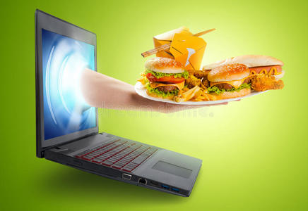 手拿着一盘从笔记本电脑屏幕里出来的食物