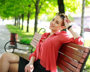 迷人的年轻女人，坐在夏天的公园里