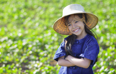 小小微笑女孩农夫在绿色的田野上