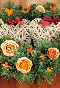 圣诞花环装饰着干桔皮木桌上的玫瑰
