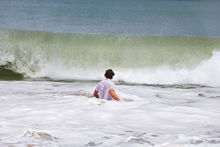 后视图的年轻人在面对一大波的海