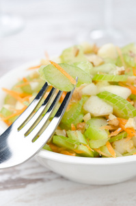 色拉配以芹菜 胡萝卜和苹果在一个白色的碗里特写