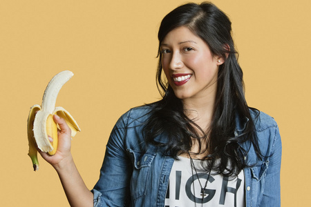 香蕉在彩色背景与年轻女子肖像