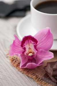 喝杯咖啡 巧克力和木制背景上兰花