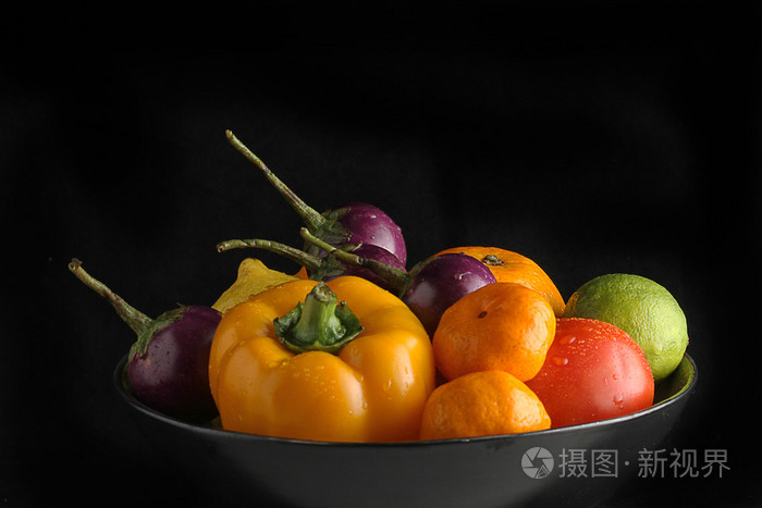 水果和蔬菜上黑碗黑色背景上孤立