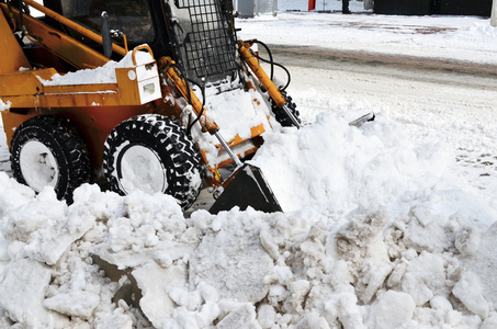 黄色拖拉机清洗街道上雪