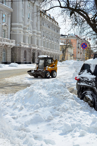黄色拖拉机清洗街道上雪
