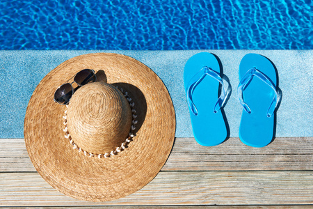 蓝色拖鞋和游泳池边的帽子