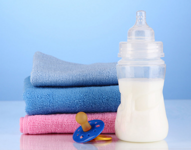 毛巾和在蓝色背景上的牛奶瓶