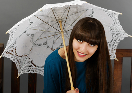 美丽的年轻女子坐在长椅上有一把雨伞在韩