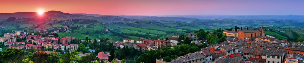 美丽的风景与圣季米尼亚诺在日落在托斯卡纳，意大利锡耶纳省的中世纪城市的全景视图