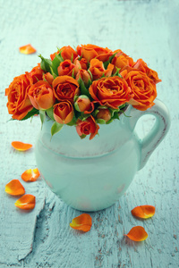橙色蓝色花瓶里的玫瑰花束