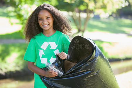 年轻的环保活动家对着镜头笑着捡垃圾
