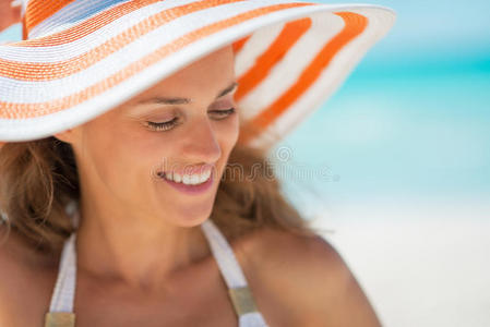 海滩上戴帽子的快乐年轻女子画像