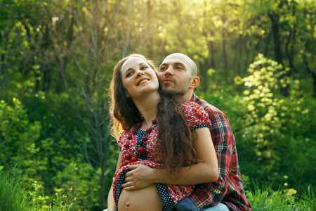 室外的年轻已婚怀孕夫妇的肖像