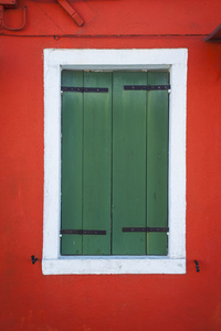 绿色百叶窗窗口中，红墙