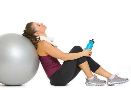 累了的健身年轻女子健身球上锻炼后放松