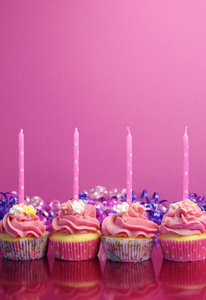粉红色的粉红色背景的圆点蜡烛的生日蛋糕。垂直与副本空间