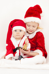 两个小女孩作为圣诞老人与响铃