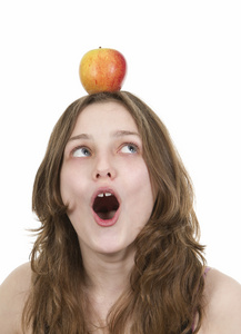 年轻女孩平衡在她头上的苹果