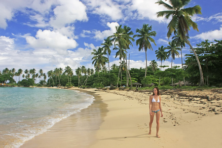 年轻女子穿比基尼走在瑞康海滩，蓬塔卡纳半岛