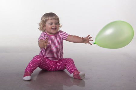 一个小女孩玩气球隔离在白色背景上