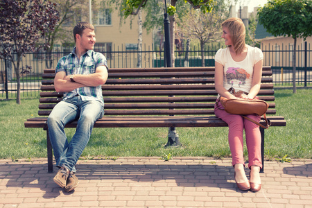 坐在公园长凳上的年轻夫妇