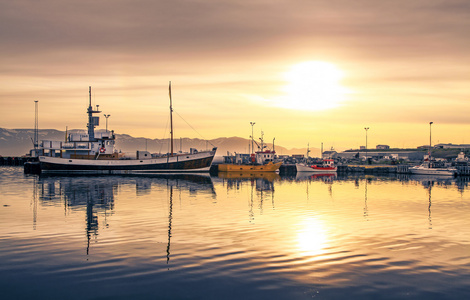 日落时分，冰岛躺在胡萨维克的港口的船只