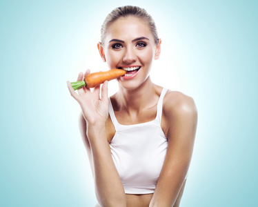 女人咬胡萝卜。概念素食主义者节食